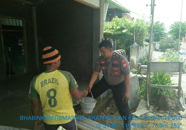 Dengan Berpakaian Lengkap, Bhabinkamtibmas Ini Bantu Warga Mengecor Lantai