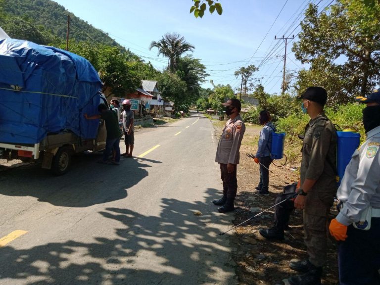 Berjaga di Perbatasan, Bhabinkamtibmas Polres Palopo Semprot Disinfektan Mobil Yang Melintas